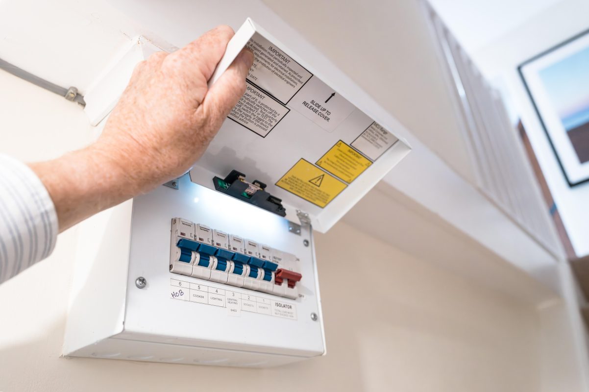 Electrician installing modern circuit breakers in a home switchboard